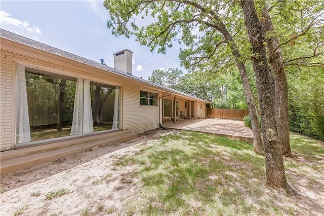 714 S Rosemary Dr, Bryan, TX 77802 - rear view of property with brick siding, a patio, and a chimney