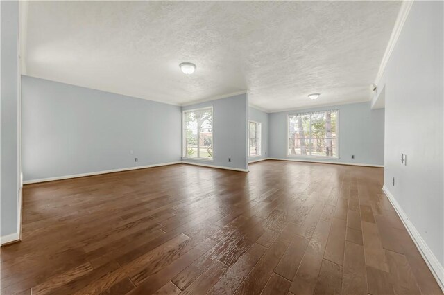 714 S Rosemary Dr, Bryan, TX 77802 - spare room featuring dark wood-style floors, plenty of natural light, a textured ceiling, and crown molding