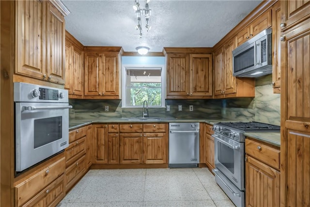 714 S Rosemary Dr, Bryan, TX 77802 - kitchen with appliances with stainless steel finishes, brown cabinetry, tasteful backsplash, dark speckled floor, and a textured ceiling
