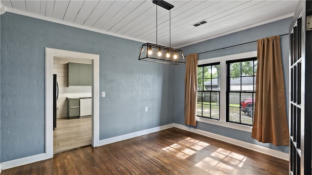 unfurnished dining area with ornamental molding, dark wood-style floors, a textured wall, and baseboards
