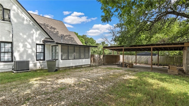 fenced backyard featuring central AC