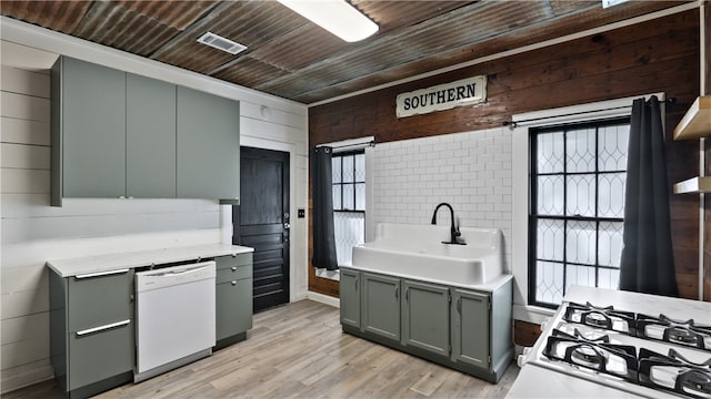 kitchen with a sink, white dishwasher, gray cabinetry, wood walls, and wood ceiling