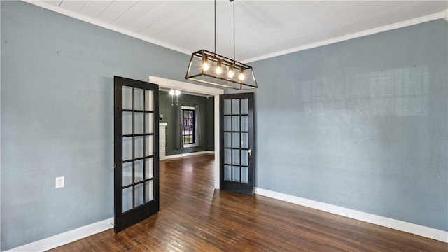 empty room with french doors, wood-type flooring, crown molding, a chandelier, and baseboards