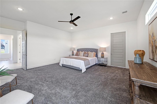 bedroom featuring dark colored carpet, ceiling fan, and multiple windows