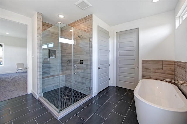 bathroom featuring shower with separate bathtub and tile patterned flooring