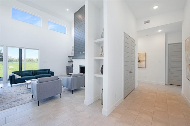 tiled living room featuring a high ceiling and built in features