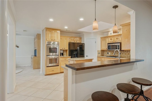 kitchen with a breakfast bar area, appliances with stainless steel finishes, backsplash, and kitchen peninsula