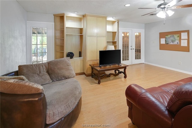 living room featuring ceiling fan, light hardwood / wood-style flooring, and french doors