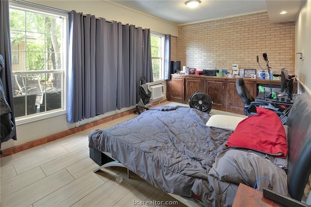 bedroom featuring a wall mounted AC and brick wall