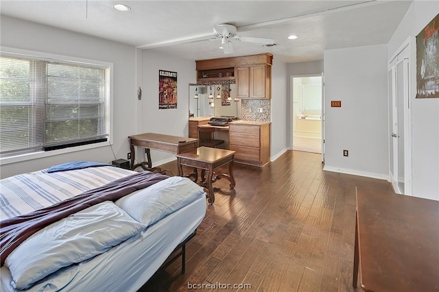 bedroom with ceiling fan, dark wood-type flooring, and connected bathroom