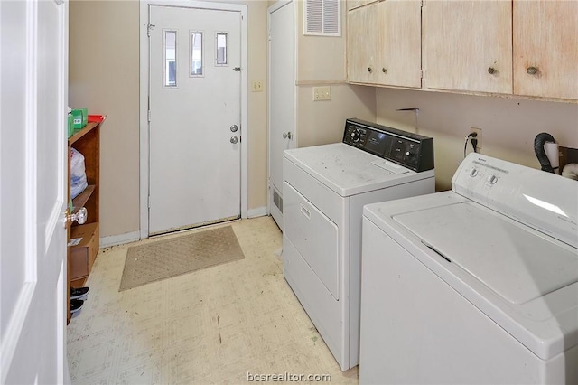 clothes washing area featuring washing machine and clothes dryer and cabinets