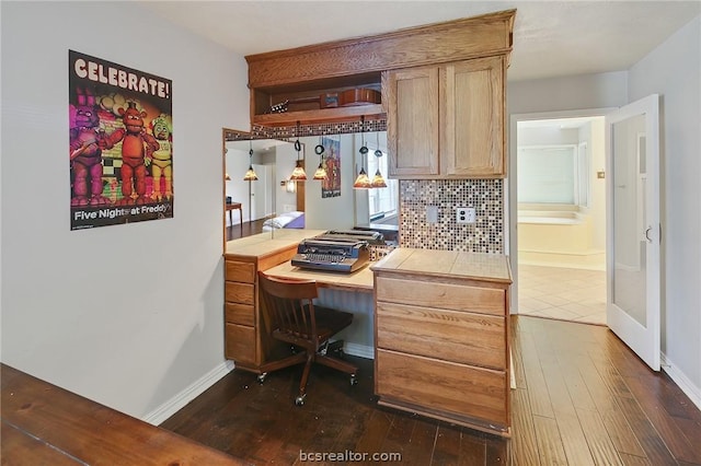 office space featuring dark hardwood / wood-style flooring and built in desk