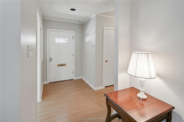 foyer featuring ornamental molding and light hardwood / wood-style flooring