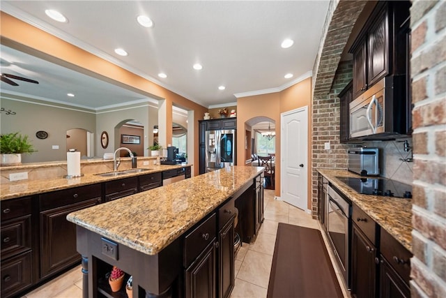 32041 Fm 1736th Rd, Hempstead, TX 77445 - kitchen featuring a sink, arched walkways, stainless steel appliances, a kitchen island, and light tile patterned floors