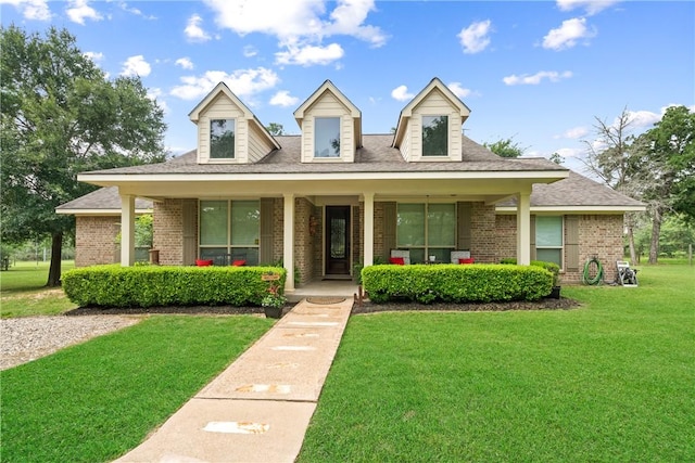 32041 Fm 1736th Rd, Hempstead, TX 77445 - cape cod home featuring brick siding, a front yard, covered porch, and a shingled roof