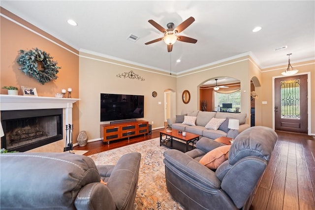 32041 Fm 1736th Rd, Hempstead, TX 77445 - living room with arched walkways, a ceiling fan, wood-type flooring, a fireplace, and crown molding