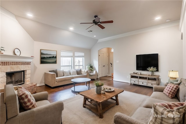 living room featuring ceiling fan, a fireplace, lofted ceiling, and dark hardwood / wood-style floors