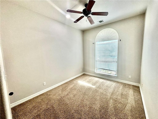 empty room featuring ceiling fan and carpet