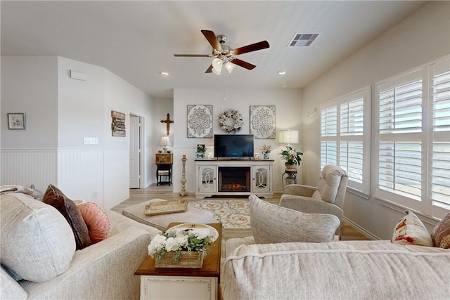 living room featuring ceiling fan and light hardwood / wood-style floors