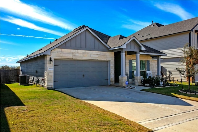 craftsman-style house with a garage, a front yard, and cooling unit