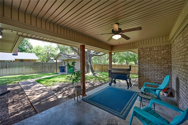 1600 Pecan St, Brenham, TX 77833 - fenced backyard featuring a patio, grilling area, a ceiling fan, and an outbuilding