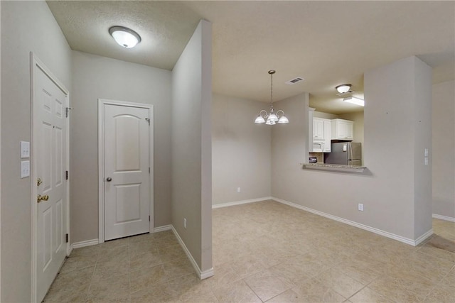 foyer featuring baseboards, light tile patterned flooring, a chandelier, and visible vents