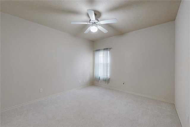 unfurnished room featuring ceiling fan, light colored carpet, and baseboards
