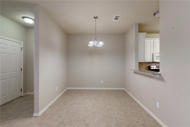 unfurnished dining area featuring a chandelier, baseboards, and visible vents