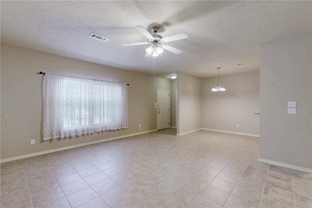 spare room with visible vents, light tile patterned flooring, baseboards, a textured ceiling, and ceiling fan with notable chandelier