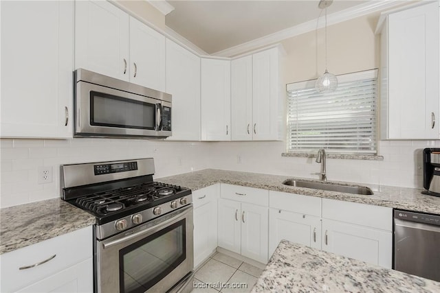 kitchen featuring white cabinets, sink, hanging light fixtures, ornamental molding, and stainless steel appliances