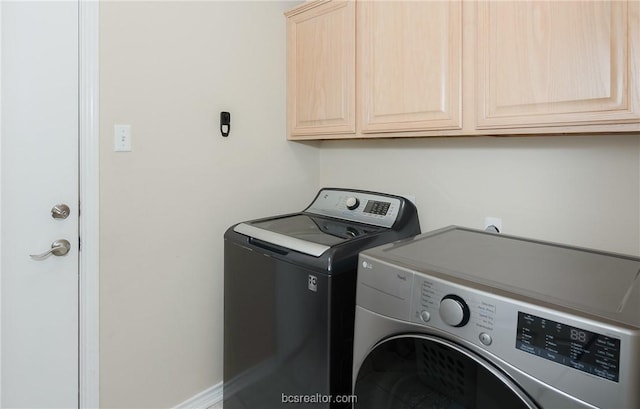 laundry room with cabinets and washer and clothes dryer