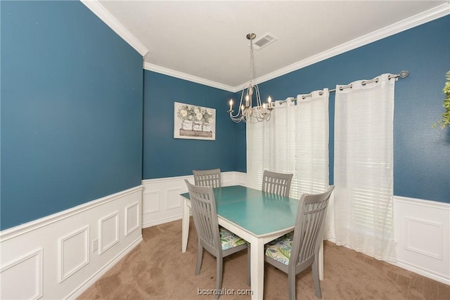 dining space featuring carpet floors, a chandelier, and ornamental molding