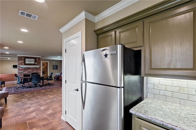 kitchen featuring recessed lighting, a fireplace, visible vents, freestanding refrigerator, and crown molding