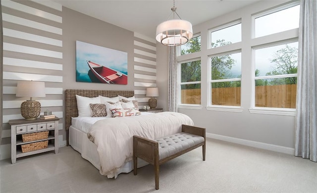 bedroom featuring light carpet, baseboards, and an inviting chandelier