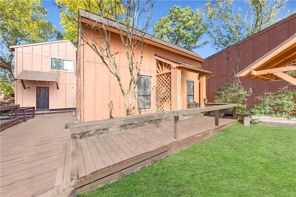 rear view of house featuring a deck and a yard