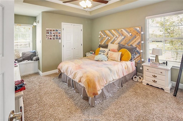 bedroom featuring light colored carpet, a ceiling fan, baseboards, a closet, and crown molding