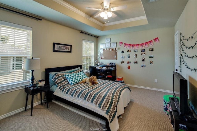 bedroom featuring baseboards, a tray ceiling, crown molding, and light colored carpet