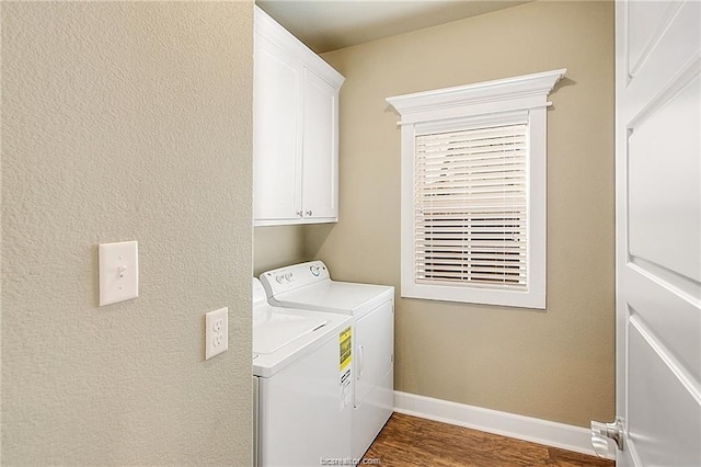 clothes washing area featuring cabinet space, baseboards, dark wood finished floors, and washing machine and clothes dryer