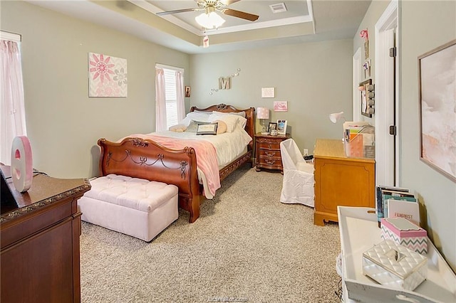 bedroom with light carpet, ceiling fan, visible vents, and a raised ceiling