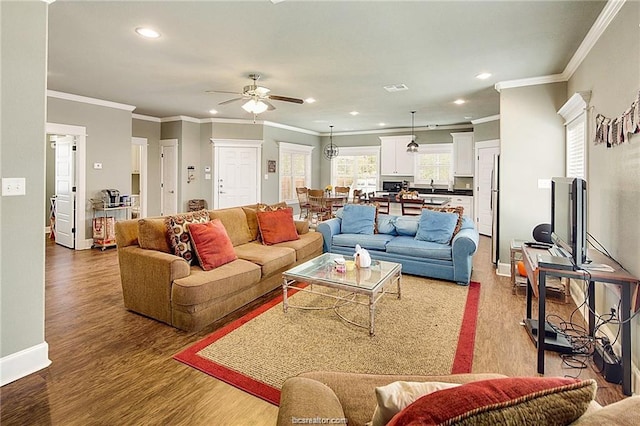 living area with recessed lighting, visible vents, baseboards, and wood finished floors