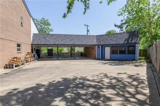 501 College View Dr, Bryan, TX 77801 - back of house with an attached carport, fence, concrete driveway, and roof with shingles