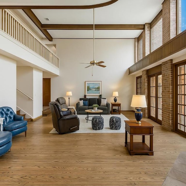 501 College View Dr, Bryan, TX 77801 - living area featuring wood finished floors, a towering ceiling, healthy amount of natural light, stairs, and ceiling fan