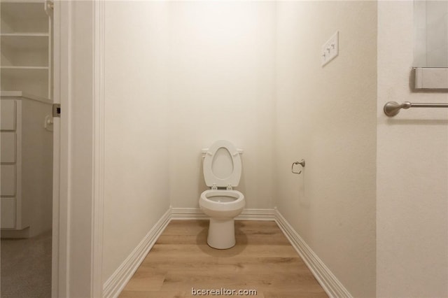 bathroom with toilet and hardwood / wood-style flooring