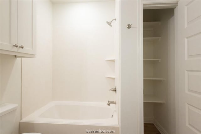 bathroom with bathtub / shower combination and toilet