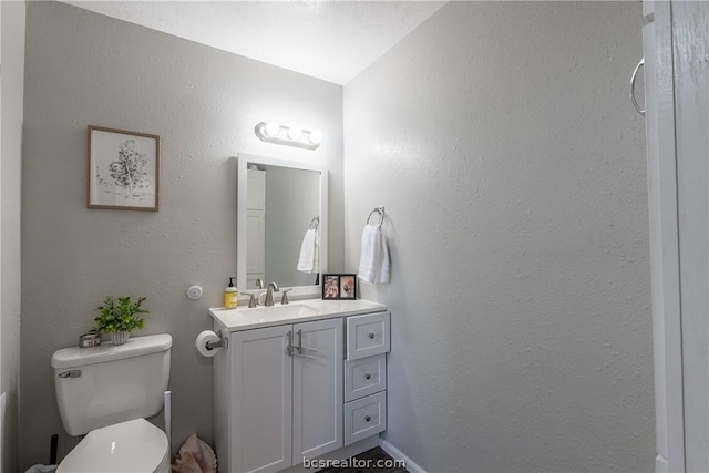 bathroom with vanity, toilet, and vaulted ceiling