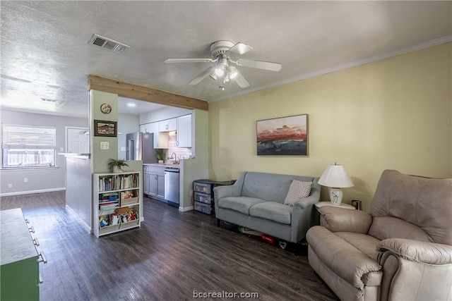 living room featuring ceiling fan, dark hardwood / wood-style flooring, crown molding, and a textured ceiling