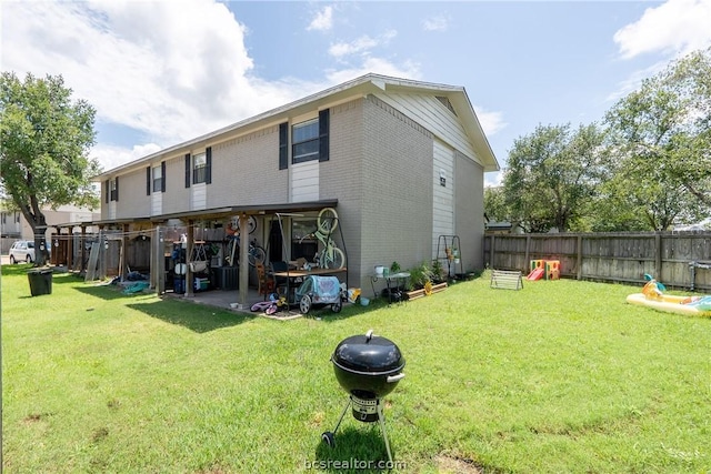 back of property featuring a fire pit and a yard