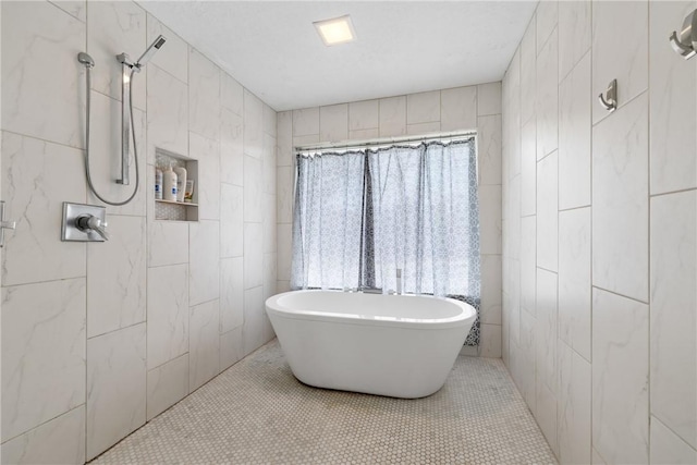 bathroom featuring tile patterned floors, tiled shower, a freestanding bath, and tile walls