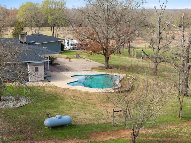 pool with a yard and a patio area