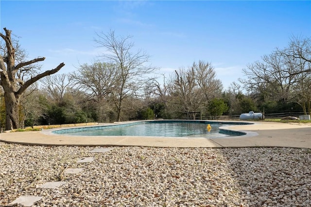 outdoor pool with a patio area and fence